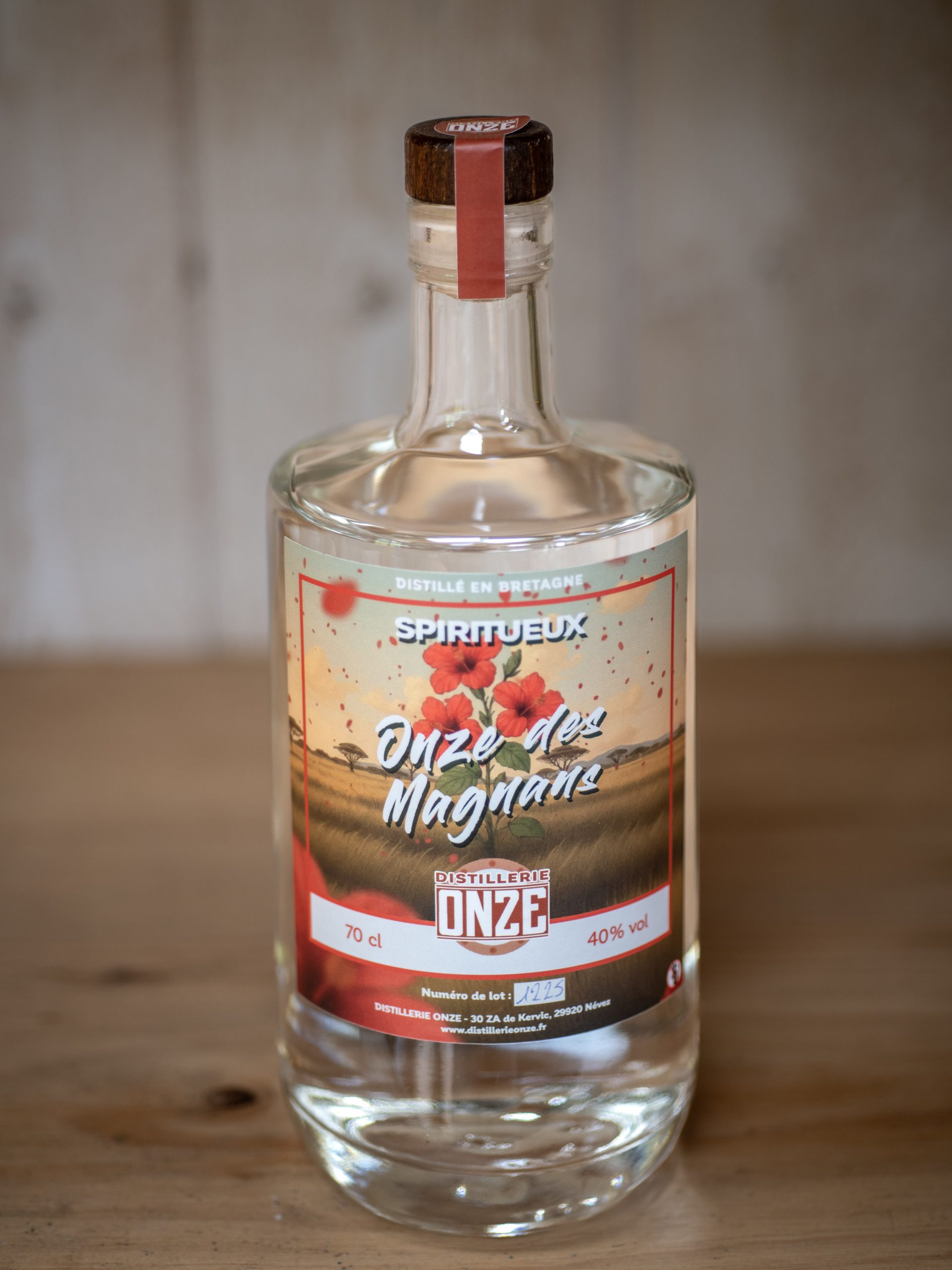 Bouteille de spiritueux "Onze des Magnans" de la distillerie Onze, posée sur une table en bois.