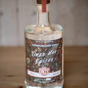 Bouteille de gin London Dry Gin "Onze des Épices" de la distillerie Onze, posée sur une table en bois.