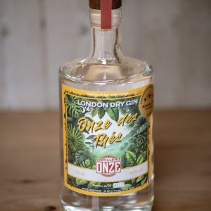 Bouteille de gin London Dry Gin "Onze des Thés" de la distillerie Onze, posée sur une table en bois.