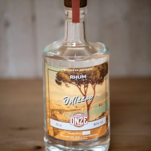 Bouteille de rhum "Odissea" de la distillerie Onze, posée sur une table en bois.