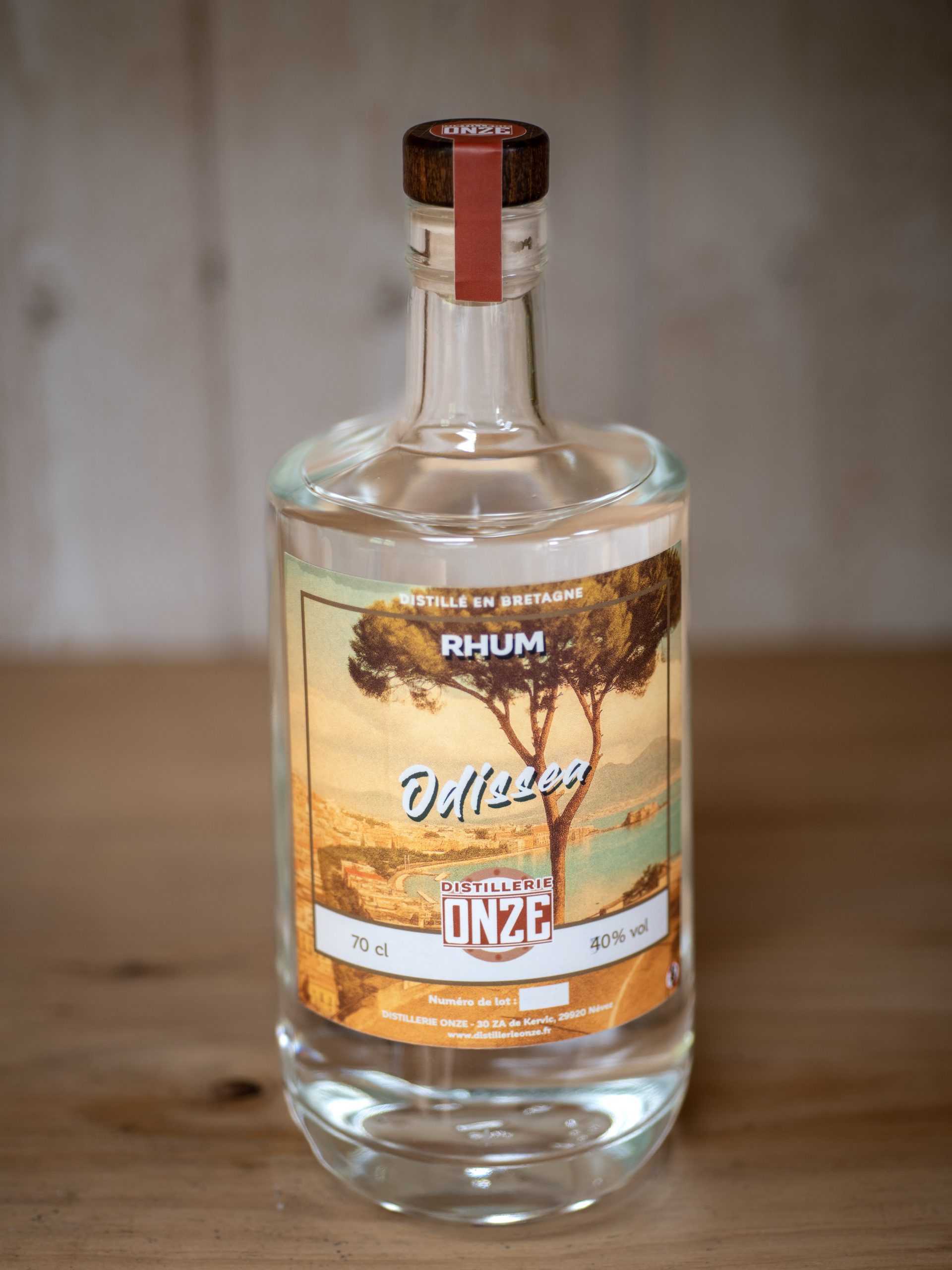 Bouteille de rhum "Odissea" de la distillerie Onze, posée sur une table en bois.