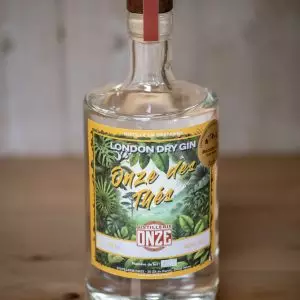 Bouteille de gin London Dry Gin "Onze des Thés" de la distillerie Onze, posée sur une table en bois.